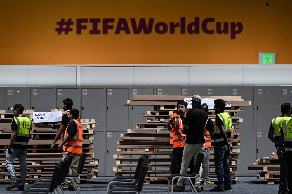Workers assemble furniture for journalists’ workstations at the Main Media Centre in Doha on November 3, 2022, ahead of the Qatar 2022 FIFA World Cup football tournament. — AFP pic