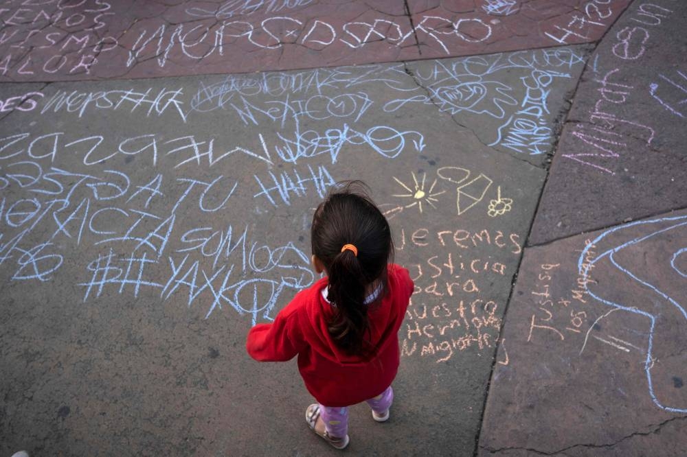 File photo of a child looking at messages written during vigil and protest held by migrants and advocates to remember the migrants who died on their travel to the United States, during the Day of the Dead celebrations in Tijuana, Baja California state, Mexico, on November 2, 2022. — AFP pic