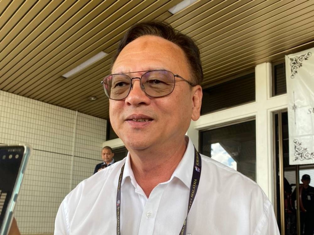 Lo speaking to reporters outside the nomination centre. — Borneo Post pic