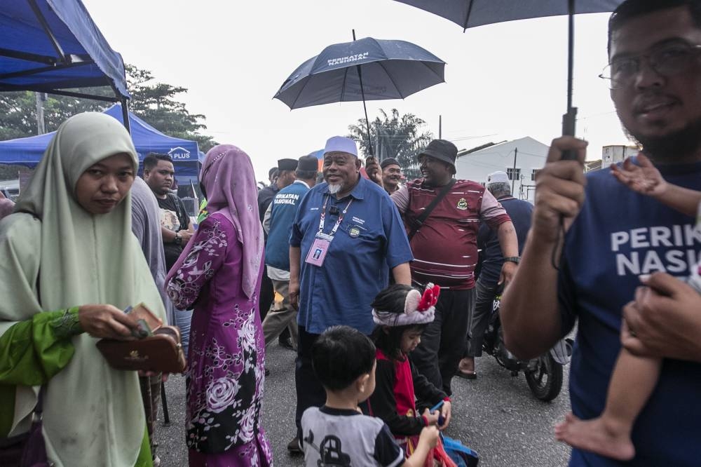 Perikatan Nasional candidate for Muar, Abdullah Husin (middle), during a walkabout session at Night Market in Parti Jawa, Muar November 6, 2022. — Picture by Hari Anggara