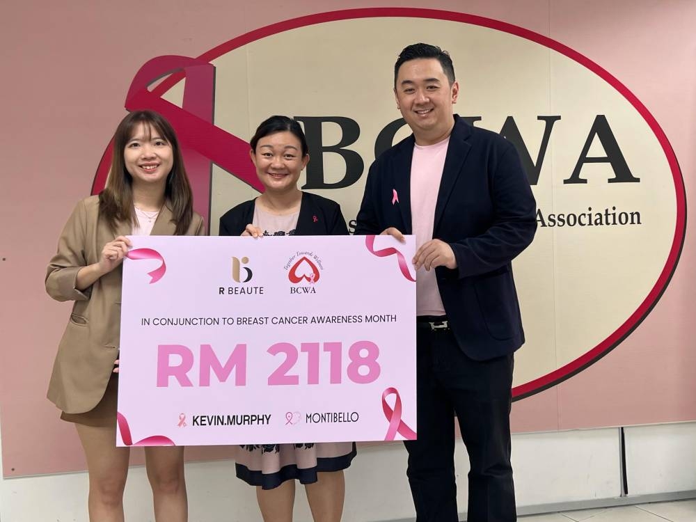 Liew (centre) receiving a mock cheque from Kow (right) and Shannon Chan of R Beaute at Breast Cancer Welfare Association Malaysia office in Petaling Jaya. — Picture courtesy of R Beaute