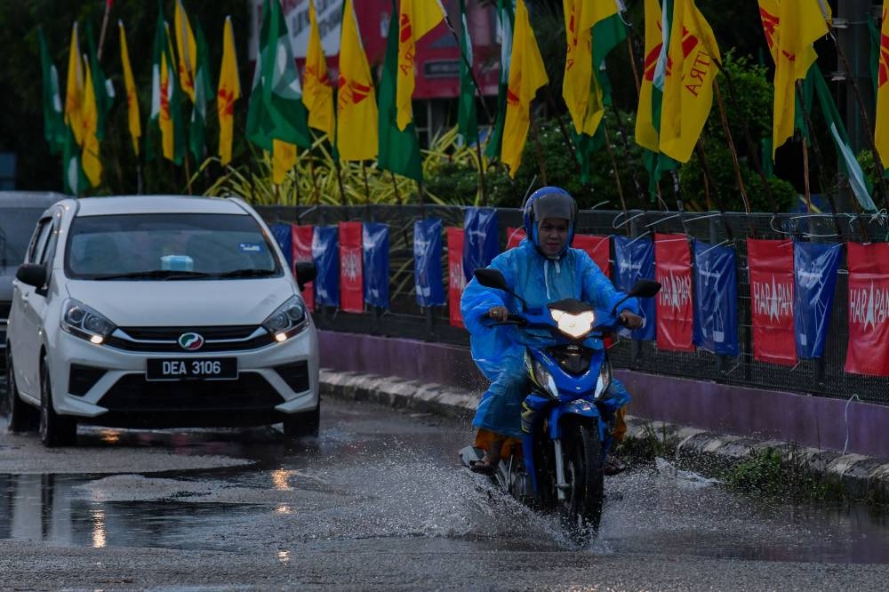 Motorists pass a row of party flags following the rain during a survey in Rantau Panjang, Pasir Mas, November 6, 2022. MetMalaysia has issued a continuous rain warning at the alert level for Kelantan, Terengganu, Pahang and Johor from tomorrow until Friday. — Bernama pic 