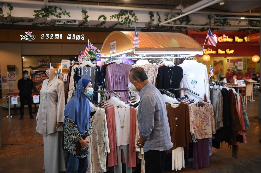 Tan Sri Muhyiddin Yassin talking to a vendor during one of the visits to various states to get the views of stakeholders. — Picture courtesy of the National Recovery Council