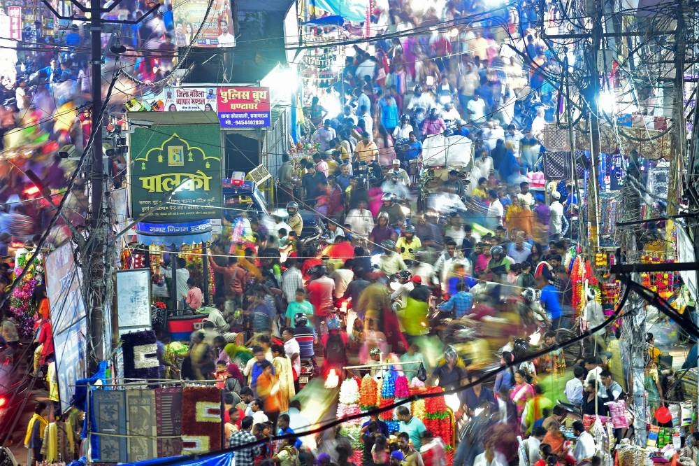 This picture taken on October 22, 2022 shows people walking through a market in Allahabad. — AFP pic