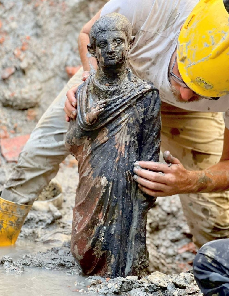 A worker holds a 2,300-year-old bronze statue which has been discovered in San Casciano dei Bagni, Italy, in this handout photo obtained by Reuters on November 8, 2022. — Ministero della Cultura handout pic via Reuters