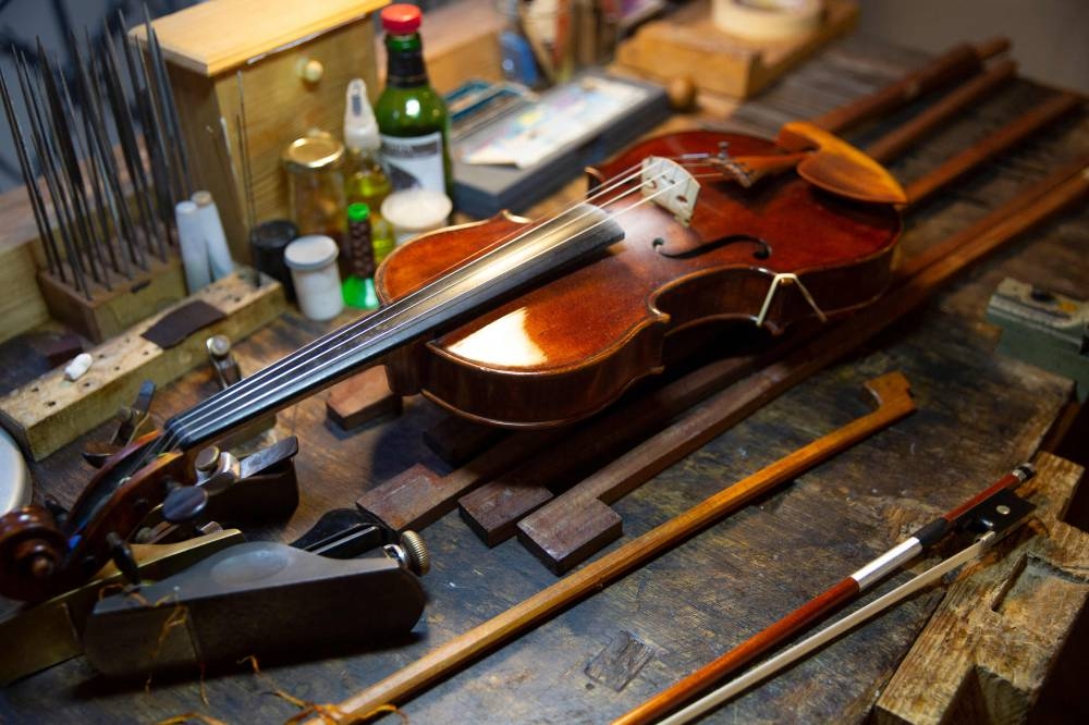This file photo taken on October 21, 2022 shows a violin and bows at the studio of French bow maker Edwin Clement in Paris. Brazil wants to ban the usage of Pernambuco wood, also known as brazilwood, essential for making bows. — AFP pic