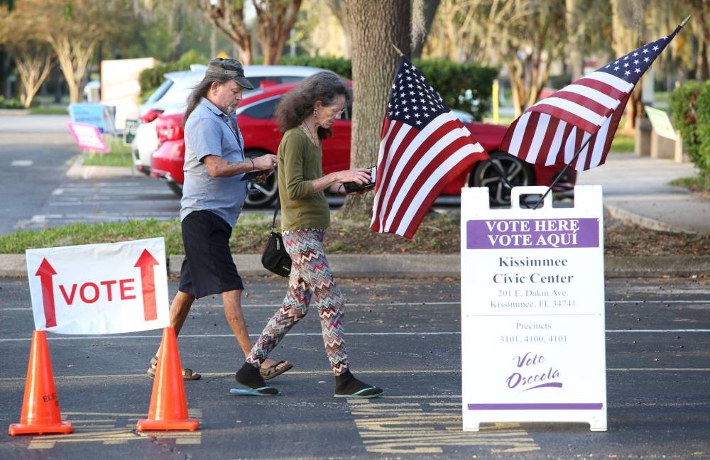 People arrive at a polling station to cast their ballots for the midterm elections in Kissimmee, Florida on November 8, 2022. — AFP pic