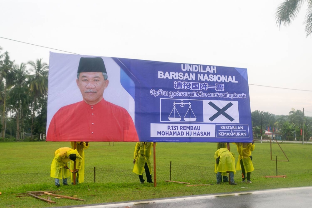 Barisan National members erect a billboard featuring its Rembau candidate Datuk Seri Mohamad Hasan along Jalan Chenong-Astana Raja in Negri Sembilan November 6, 2022. — Picture By Raymond Manuel