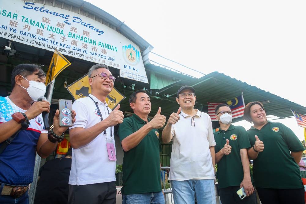Ong (third from right) and Bryan Lai Wai (second from left), Warisan's Ampang candidate, pose for a picture at the Taman Muda wet market November 6, 2022. 