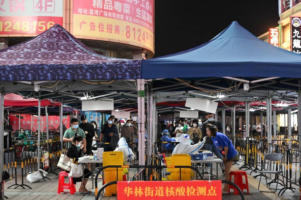 People line up to take nucleic acid test for Covid-19 following the outbreak, at a makeshift testing site in Guangzhou, Guangdong province, China November 9, 2022. — cnsphoto via Reuters pic