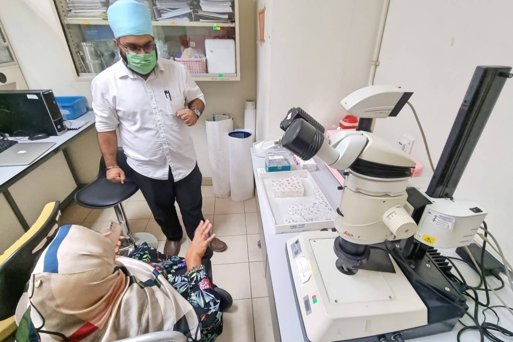 Noraishah Mydin Abd Aziz speaks to one of her lab assistants in her imaging lab in the Parasitology Department, University of Malaya, November 1, 2022. — Picture by Zurairi A.R.