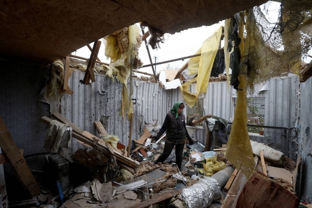 Local resident Serhii Tamara removes debris inside a house of her son, destroyed during a Russian military attack in the village of Novooleksandrivka, in Kherson region, Ukraine November 9, 2022.  — Reuters pic