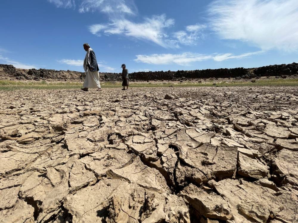 People walk on the cracked soil caused by drought on the outskirts of Sanaa, Yemen, October 20, 2022. —  Reuters pic