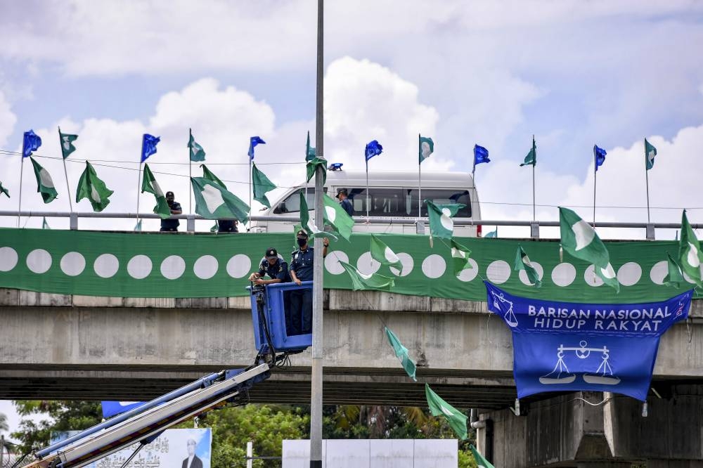 Kuala Terengganu City Council enforcement members remove PAS flags after endangering road users during a survey around Manir in Terengganu, November 10, 2022. — Bernama pic 
