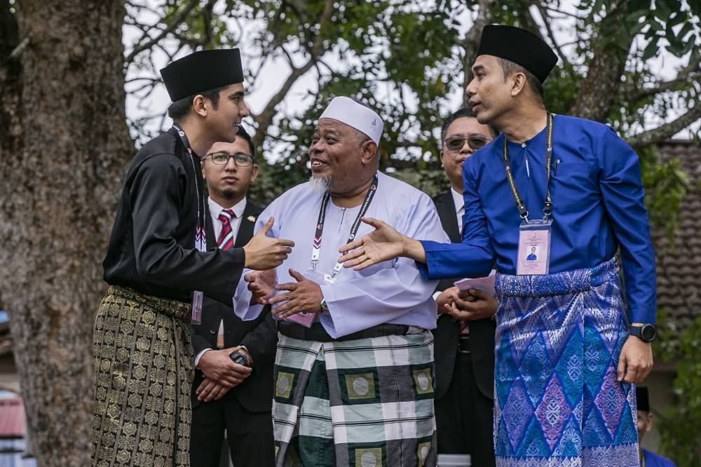Syed Saddiq (left), Mohd Helmy (right) and Perikatan Nasional candidate Utstaz Abdullah Husin exchange greetings after their candidacy announcements in Muar, November 5, 2022. — Picture by Hari Anggara