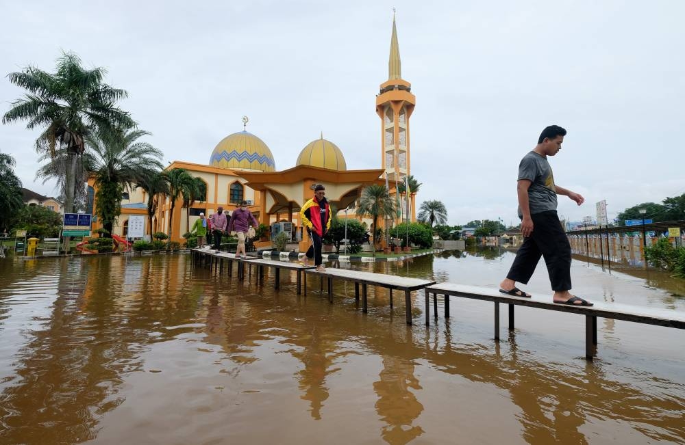 Mosque congregants use a specially made footbridge after the As-Syarif mosque along Jalan Hamzah Alang Meru in Klang was inundated with floodwater, November 11, 2022. — Bernama pic 
