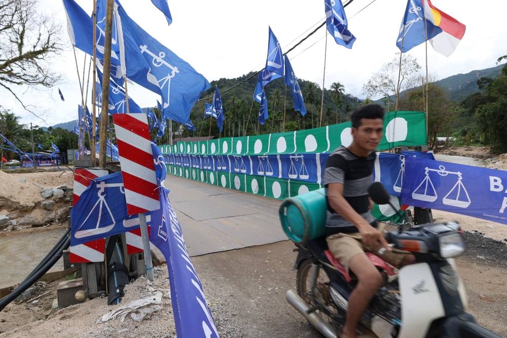 Party flags line a bridge at Kampung Iboi in Baling November 11, 2022. — Bernama pic