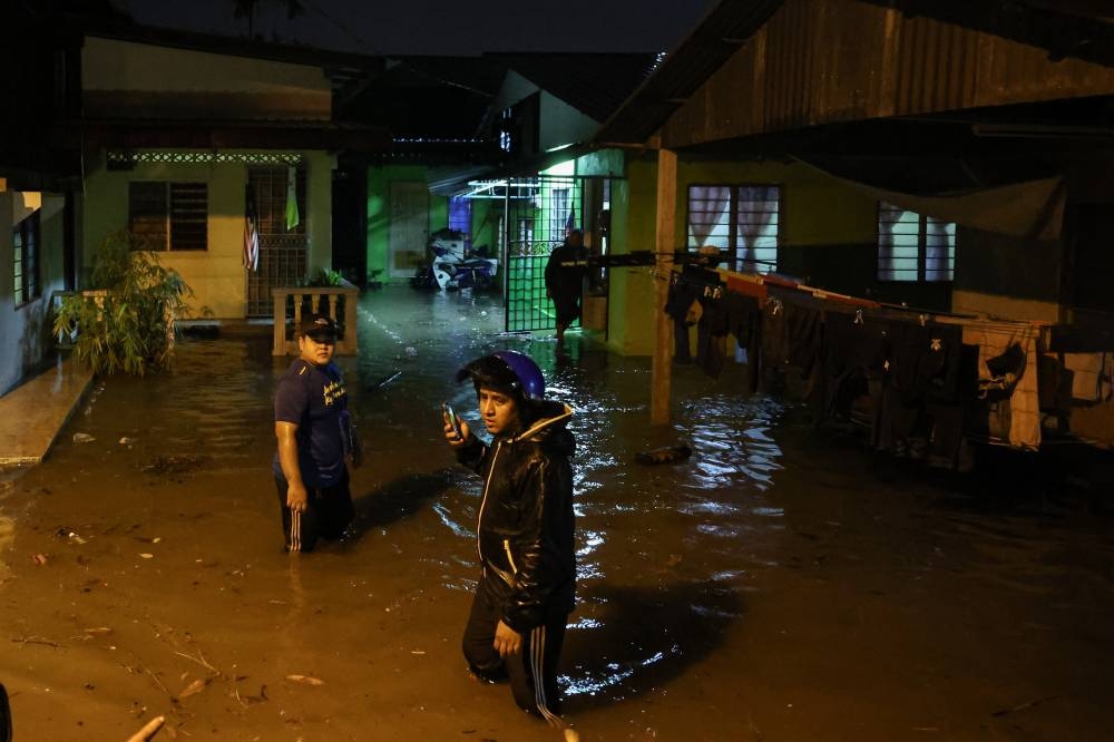 Kampung Baru Alma residents wade in flood water following heavy rain in Bukit Mertajam November 11, 2022. — Bernama pic