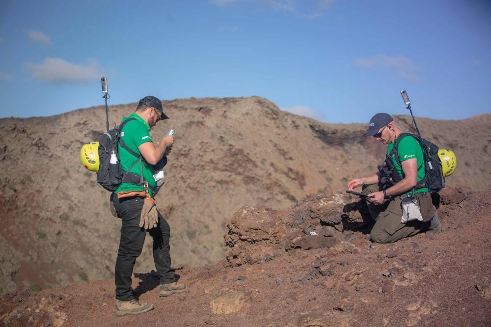 German astronaut Alexander Gerst (right) collects rock on the summit of an ancient volcano during a training program to learn how to explore the Moon and Mars in the Timanfaya National Park in the Canary island of Lanzarote on November 10, 2022. ― AFP pic