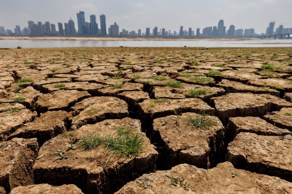File photo of cracks running through the partially dried-up river bed of the Gan River, a tributary to Poyang Lake during a regional drought in Nanchang, Jiangxi Province, China, August 28, 2022. ― Reuters pic