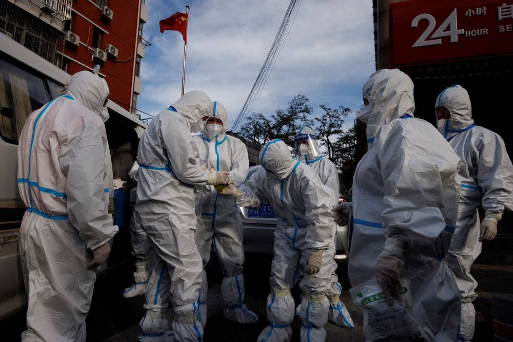 Pandemic prevention workers in protective suits prepare to enter an apartment compound that was placed under lockdown as outbreaks of the coronavirus disease continue in Beijing, China, November 12, 2022. ― Reuters pic