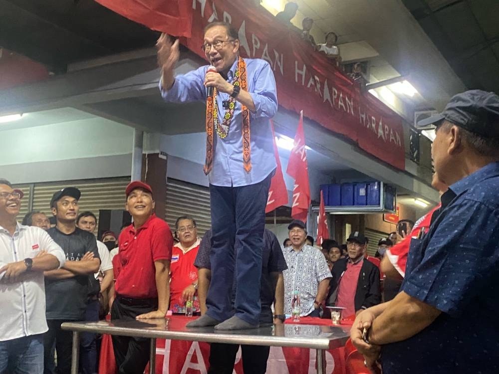 Pakatan Harapan chairman Datuk Seri Anwar Ibrahim stands atop a table to deliver a speech during a political rally in Putatan. November 12, 2022. — Picture by Julia Chan