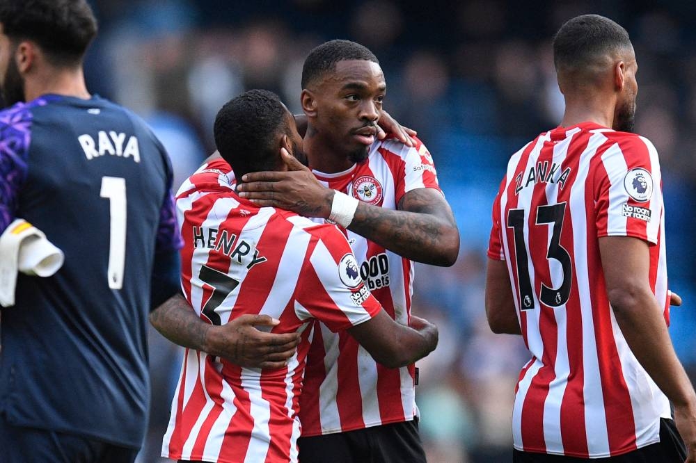 Brentford’s English striker Ivan Toney (centre) celebrates with Brentford’s English defender Rico Henry (left) on the pitch after the English Premier League football match between Manchester City and Brentford at the Etihad Stadium in Manchester, north west England, on November 12, 2022. ― AFP pic