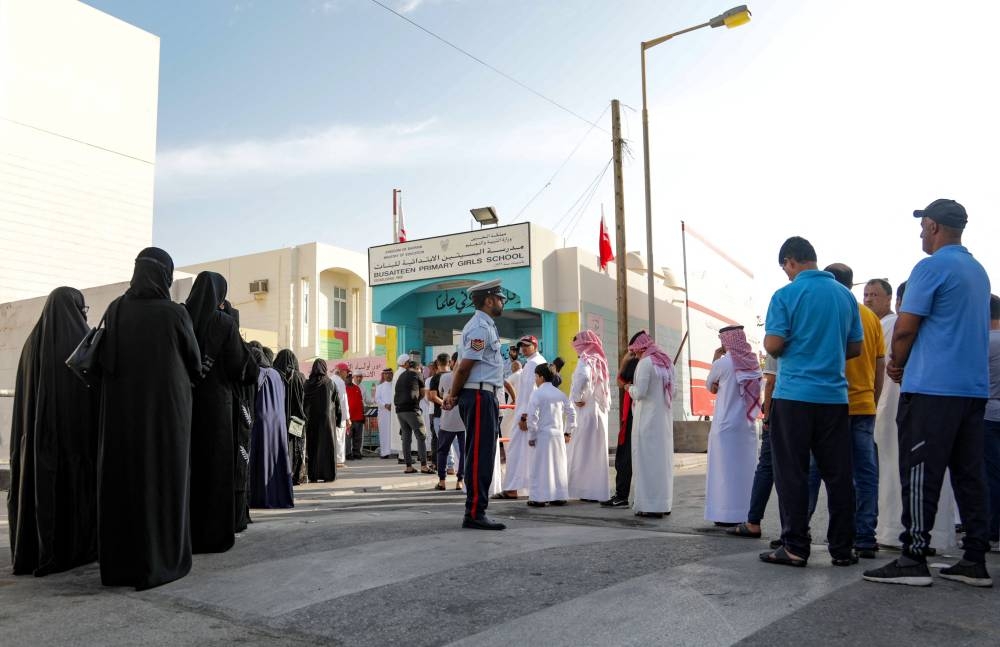 Bahrainis queue in front of a polling station on the island of Muharraq, north of the capital Manama, during parliamentary elections, on November 12, 2022. — AFP pic