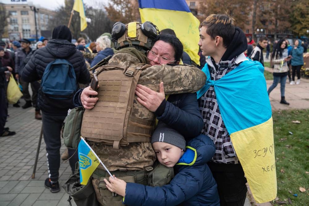 Local residents hug a Ukrainian soldier as they celebrate the liberation of Kherson, on November 13, 2022, amid Russia's invasion of Ukraine. — AFP pic