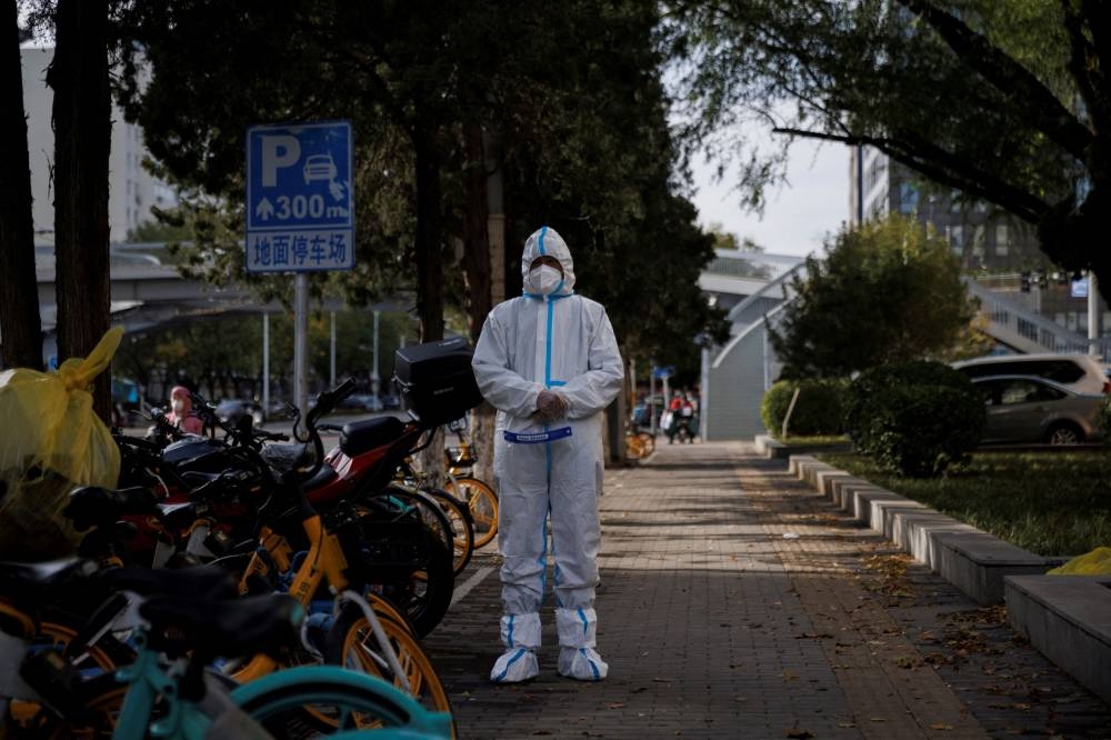A pandemic prevention worker in a protective suit stands outside an apartment compound that was placed under lockdown as outbreaks of Covid-19 continue in Beijing, China, November 12, 2022. — Reuters pic