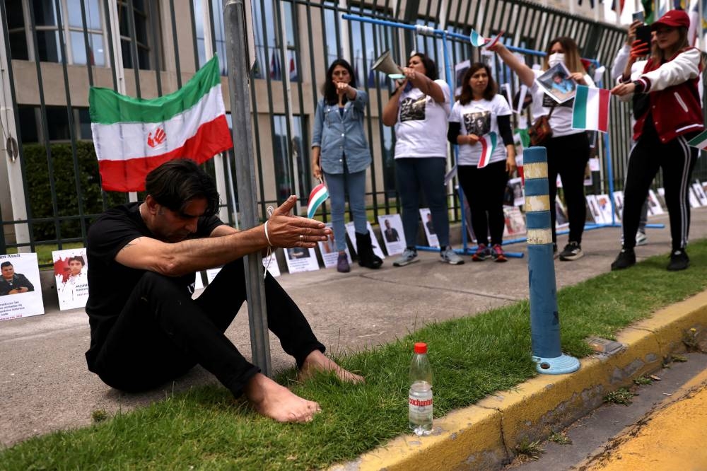 A member of the Iranian community living in Chile ties himself as they protest outside the United Nations local headquarters in solidarity with Iranian people, in Santiago, Chile, November  11, 2022. — Reuters pic