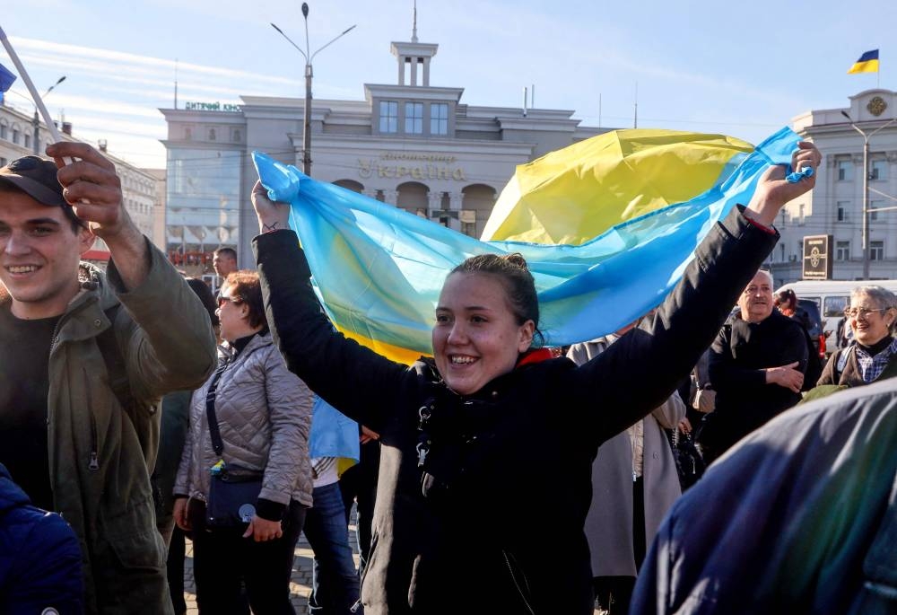 A woman waves a Ukrainian flag in the centre of the recently recaptured city of Kherson November 14, 2022. — AFP pic