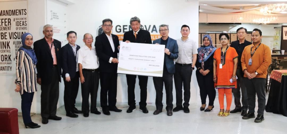 Tan Sri Lim Hock San (fifth from the right) presents a mock cheque for RM80,000 to Prof James Nga witnessed by Datuk Siew Ka Wei. — Picture courtesy of Genovasi University College