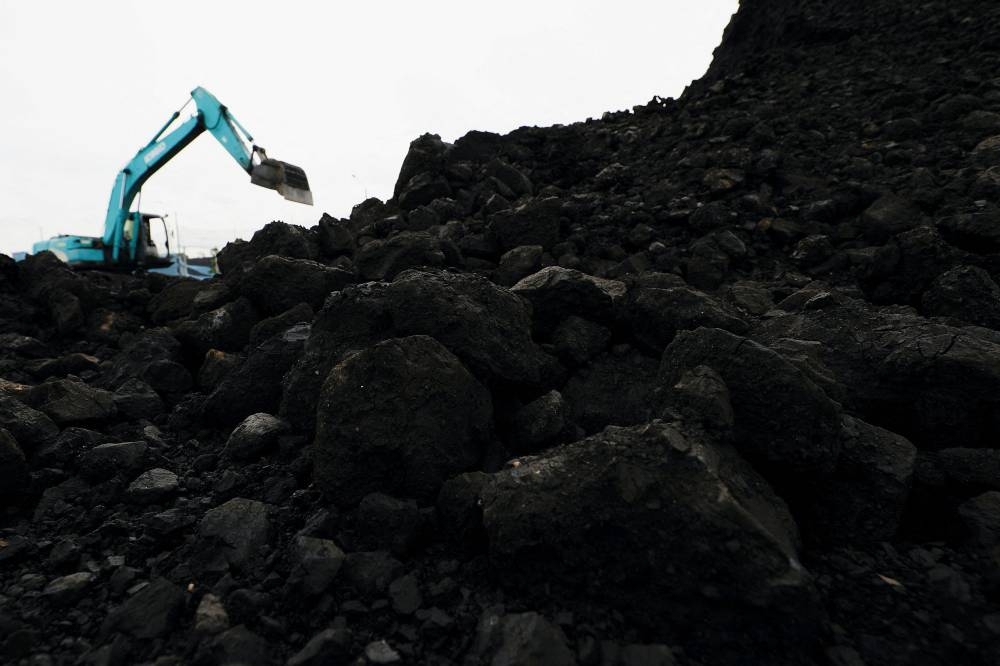 Coal is seen as a heavy machinery unloads it from the barges into a truck to be distributed, at the Karya Citra Nusantara port in North Jakarta, Indonesia, January 13, 2022. Picture taken January 13, 2022. — Reuters pic