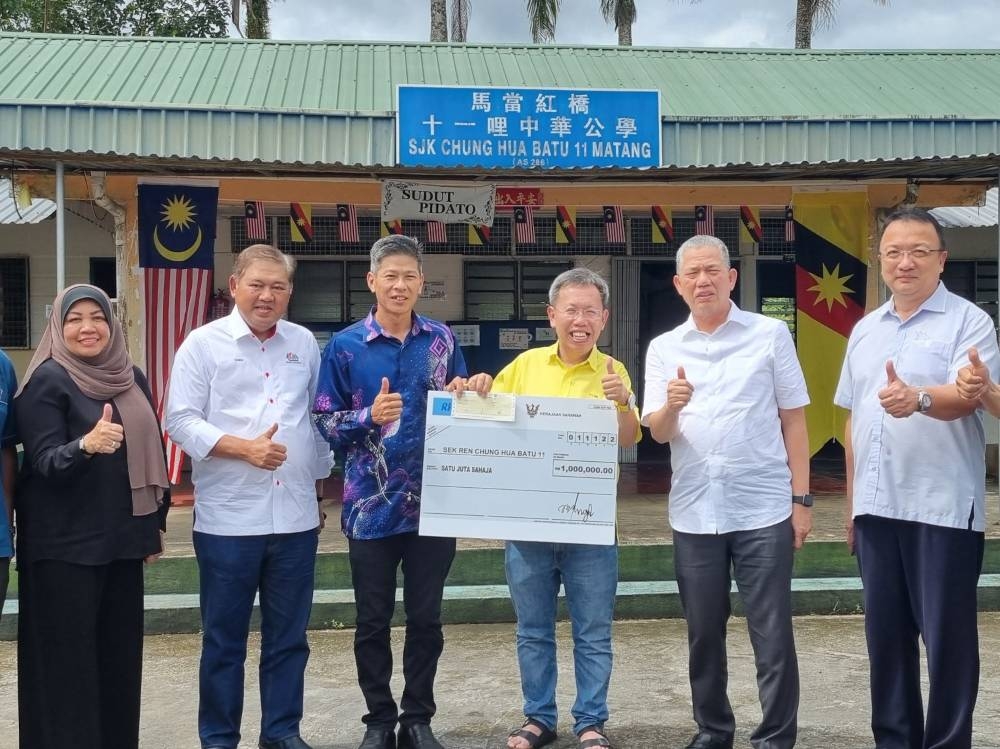 Deputy Premier Datuk Seri Dr Sim Kui Hian (3rd right) seen handing over a mock cheque to the Matang SJK Chung Hua Batu 11 officials at the school yesterday. Also seen are Datuk Seri Fadillah Yusof (2nd right) and other officials. — Borneo Post pic 