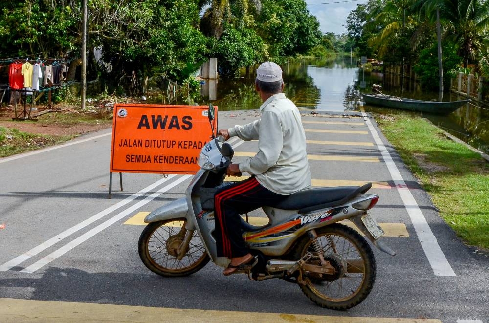 A man surveys rising water levels in Kampung Tersang, Pasir Mas November 15, 2022. — Bernama pic