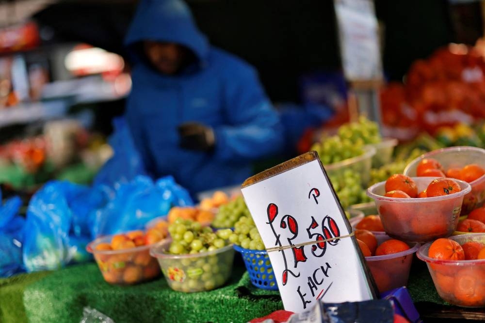 In this file photo taken on February 04, 2022 A sign displays the cost of tomatoes at a fruit and vegetable stall at a market in Walthamstow, east London. — AFP pic