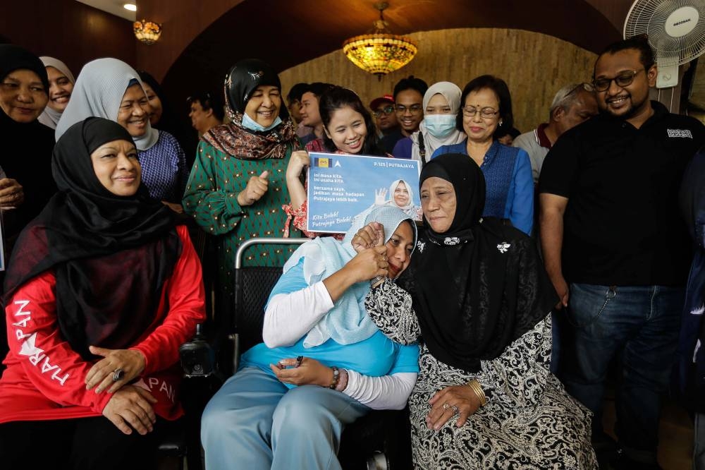 Pakatan Harapan’s Noraishah Mydin Abd Aziz (in wheelchair) receives the backing of Putrajaya grassroots campaigners when meeting their volunteers in Precinct 11, Putrajaya. — Picture by Sayuti Zainudin