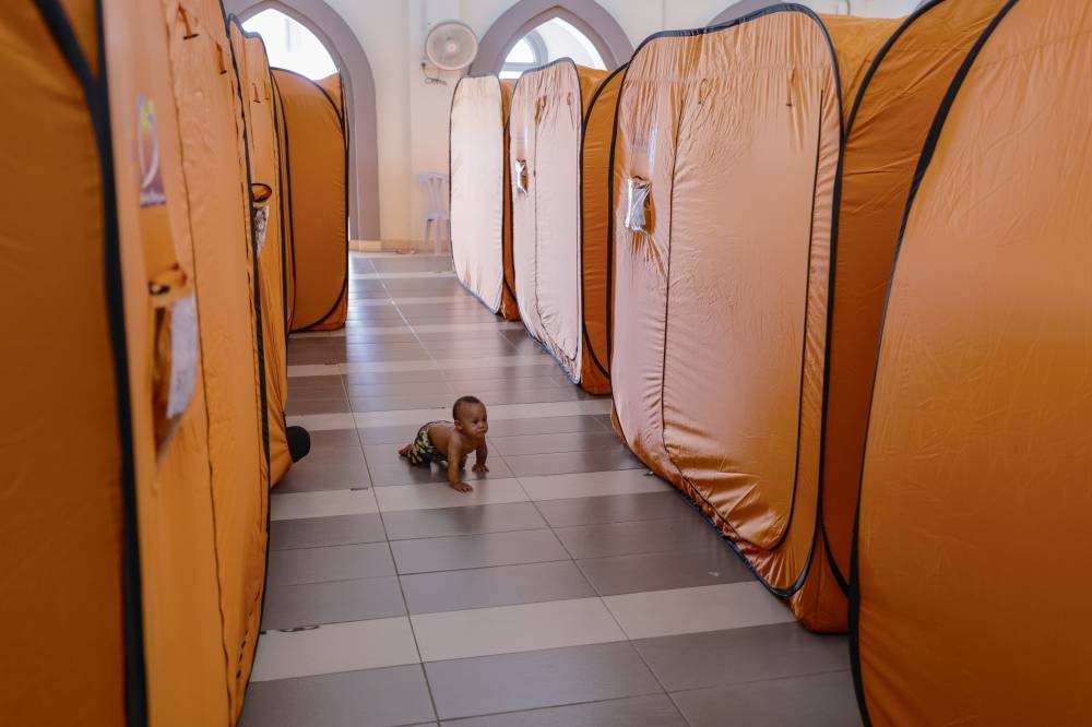 A baby pictured crawling on the floor at the Masjid Kampung Johan Setia temporary flood relief centre in Klang, November 17, 2022. — Bernama pic 