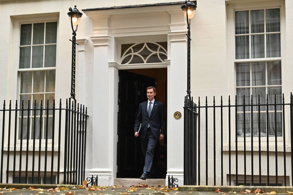 Britain's Chancellor of the Exchequer Jeremy Hunt walks out of Number 11 Downing Street in central London on his way to make a full budget statement in the House of Commons on November 17, 2022. - Britain is set to unveil hefty tax rises and spending cuts at the risk of worsening a cost-of-living crisis for millions in the recession-bound economy. — AFP pic
