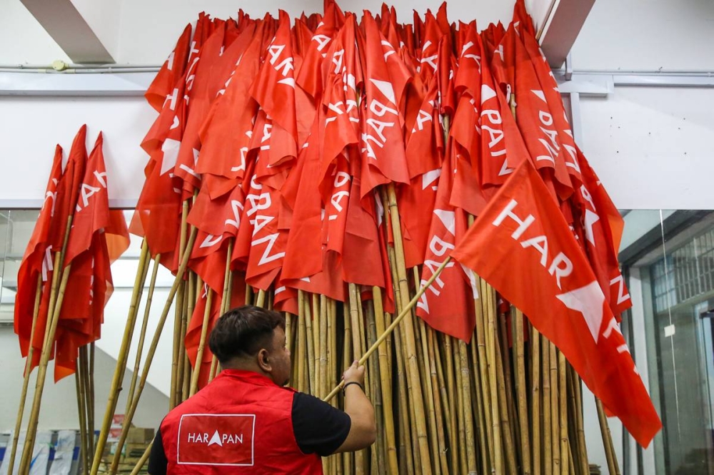 A party worker prepares Pakatan Harapan flags during the campaign period ahead of the 15th general election at Taman Gaya Ulu Tiram in Johor Baru November 7, 2022. — Picture by Yusof Mat Isa