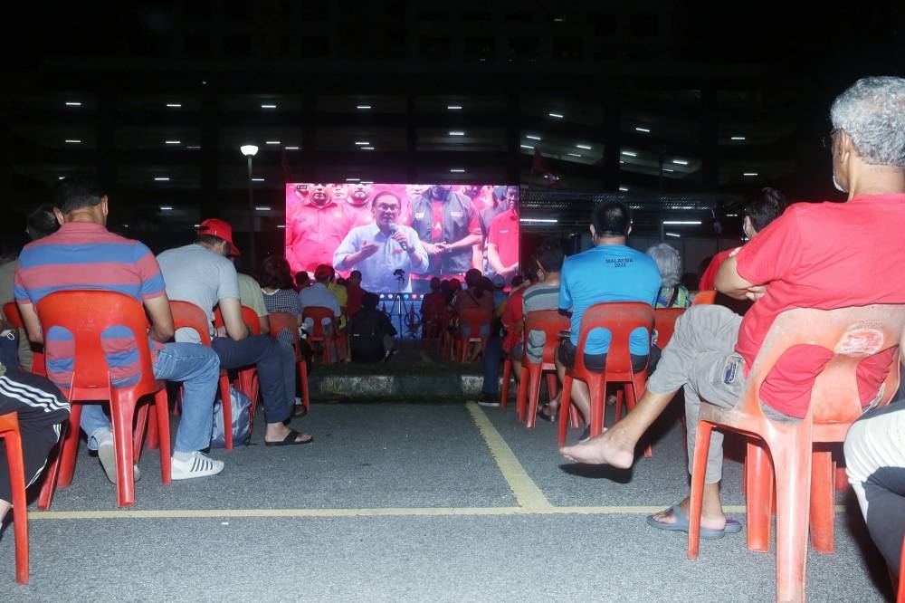 The crowd watching Datuk Seri Anwar Ibrahim’s live telecast from Tambun in the Pakatan Harapan ceramah grand finale Damansara at the Kelana Jaya Stadium carpark, Nov 18, 2022. —  Picture by Choo Choy May