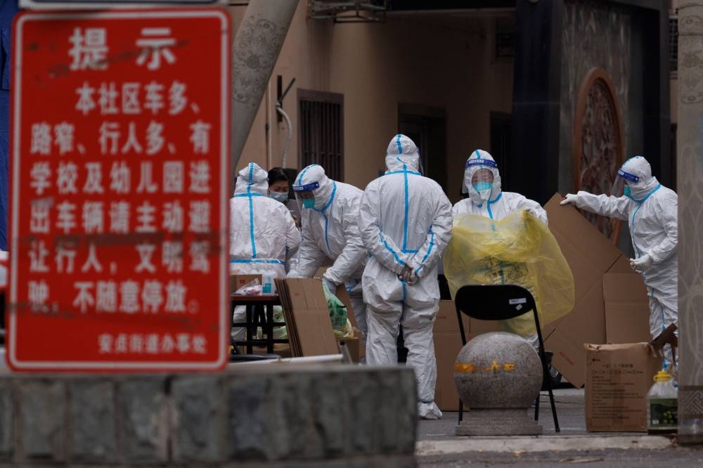Pandemic prevention workers in protective suits collect trash in a locked-down residential compound as outbreaks of the coronavirus disease continue in Beijing, China November 18, 2022. — Reuters pic