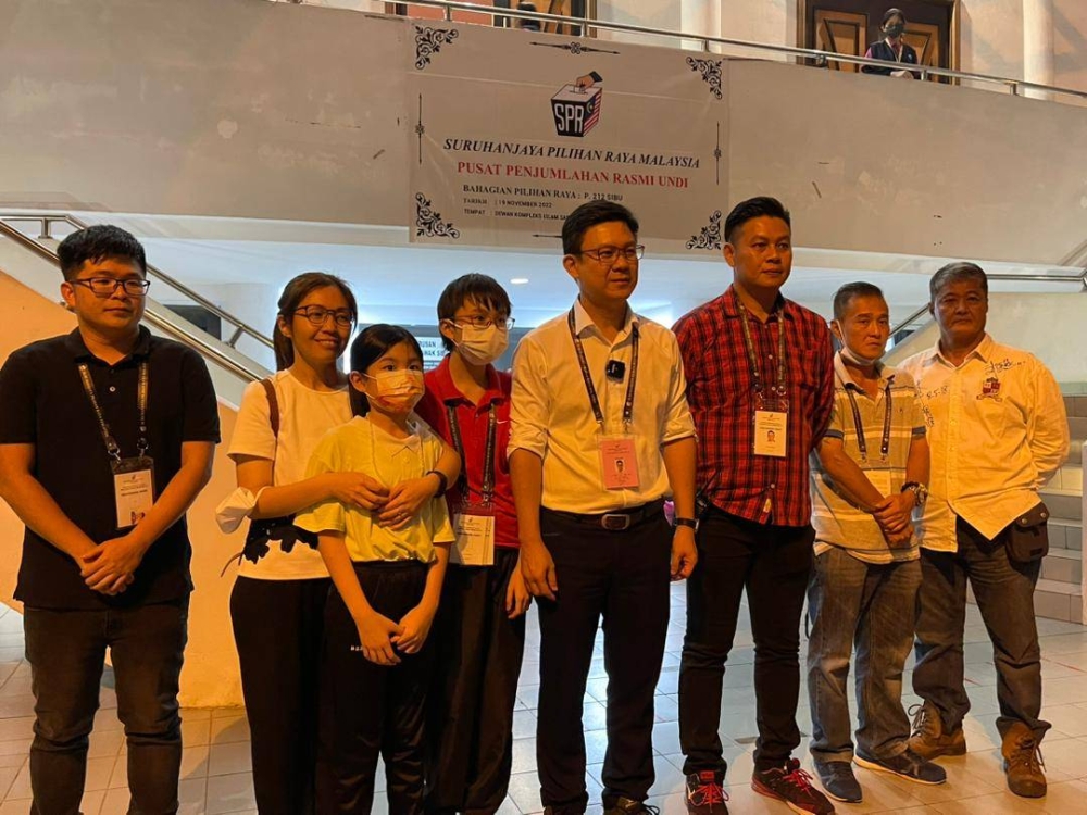Ling (5th left) with his family members outside the tallying centre. — Borneo Post pic