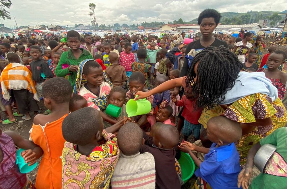 Internally displaced children wash their hands as they wait to receive porridge from volunteers at Kayembe primary school in Munigi camp near Goma, in the North Kivu province of the Democratic Republic of Congo, November 18, 2022. — Reuters pic