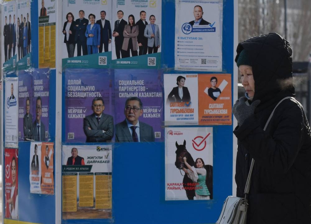 A pedestrian walks past campaign posters of presidential candidates in Astana on November 18, 2022, ahead of Kazakhstan's presidential elections on November 20. — AFP pic