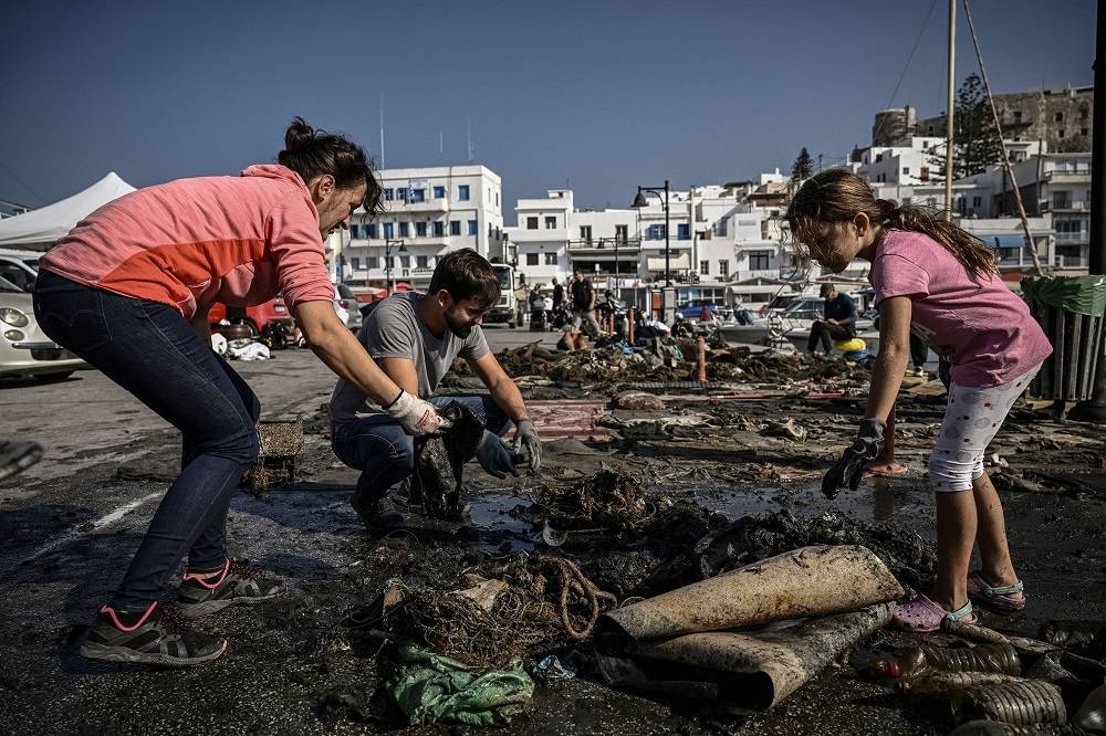 Members and volunteers of the Aegean Rebreath NGO, sort rubbish that divers collected under the water during a clean-up operation of the harbour of the Cycladic island of Naxos. — AFP pic
