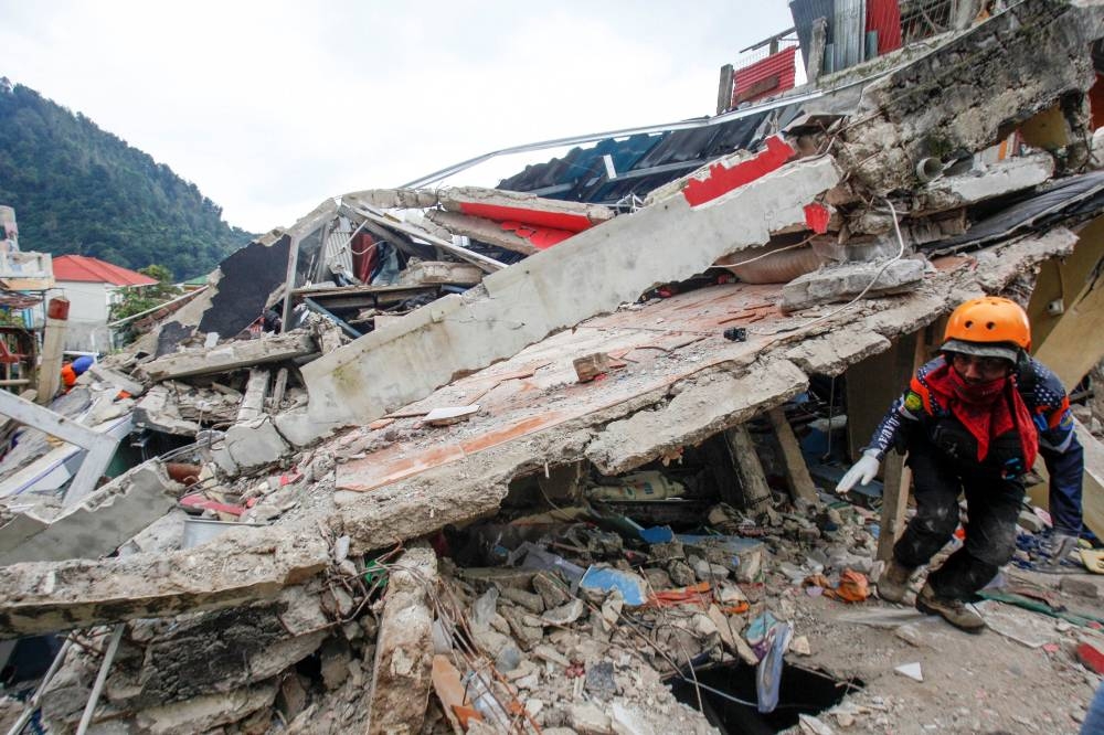 A rescuer walks among the rubble of collapsed buildings during a rescue operation after earthquake hit in Cianjur, West Java province, Indonesia, November 22, 2022, in this photo taken by Antara Foto. ― Antara Foto/Yulius Satria Wijaya/ via Reuters