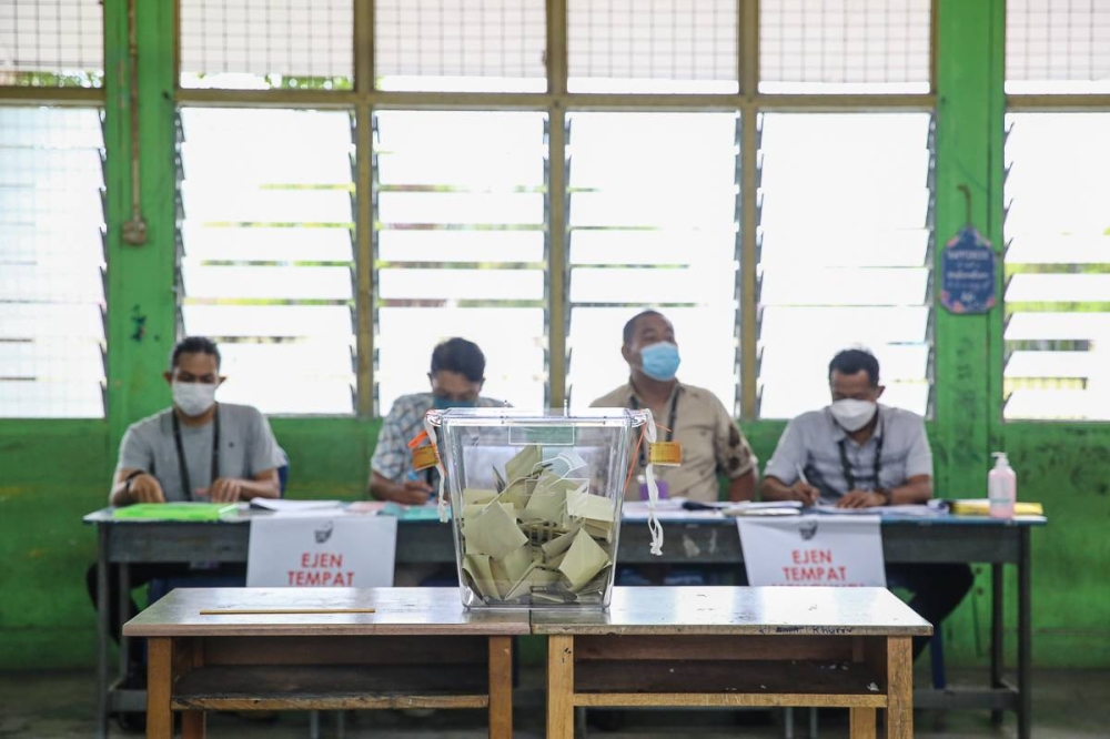 2022 年 11 月 19 日，在莎阿南 Sekolah Kebangsaan Seksyen 17 举行的第 15 届大选期间，投票中心的桌子上放着一个投票箱。图片来自 Yusof Mat Isa