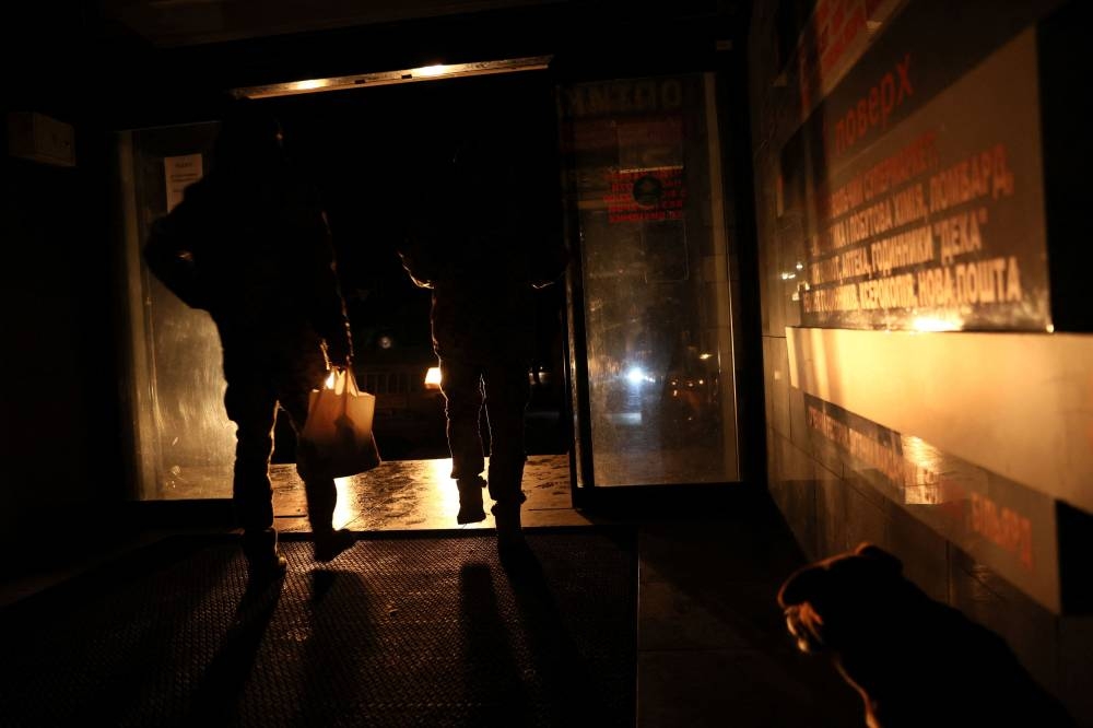 People file in and out of a market during a power outage as Russia's attack on Ukraine continues in Kramatorsk, Ukraine November 24, 2022. ― Reuters pic